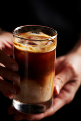 A man holding iced latte