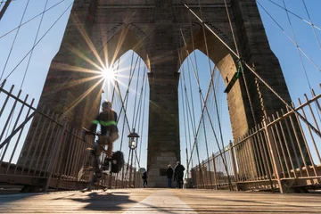 Tuinposter Scene of stop motion bicycle with Brooklyn bridge when sunrise, USA downtown skyline, Architecture and building with tourist concept © THANANIT