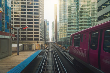 Elevated Train Tracks are running above the Railroad tracks between the building at the Loop line at Chicago, Illinois, USA