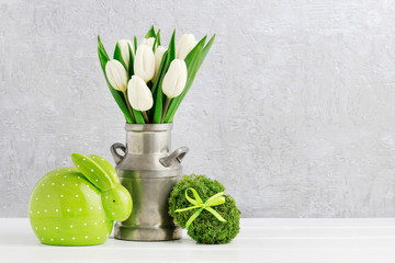 Easter decoration with green rabbit, egg made of moss and bouquet of tulips