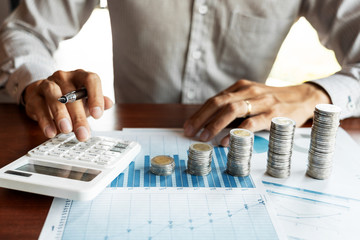 Businessman accountant Calculating on data documents And pile Stack Of coins, the savings money investment. financial Budget planning concept
