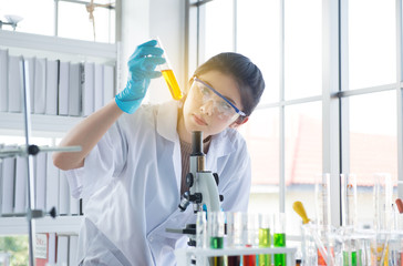 Scientist asian woman working and looking medical chemicals sample in test tube at laboratory
