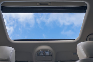 View of the cloudy sky through the open hatch of the car