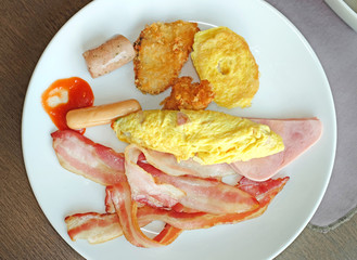 breakfast sausage, omelet and bacon on white plate