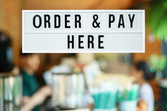 A business text ‘Order and Pay here’ on blurred of cafe or restaurant entrance background. Industry food, Cafe and restaurant idea concept. Image with clipping path.