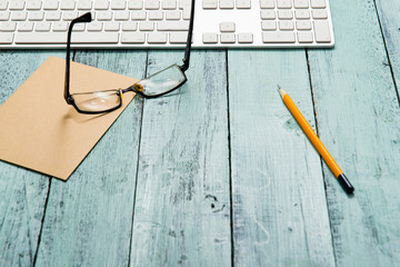 keypad, eyeglasses, recycled note paper on blue wooden table