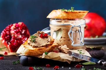 Meat liver pate on toasted bread with fruit seeds and spice herb, brown kitchen table, copy space,...