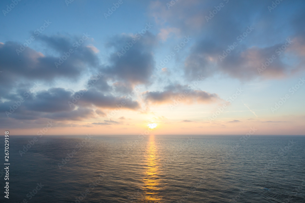 Wall mural beautiful sunset over sea , majestic clouds in the sky .