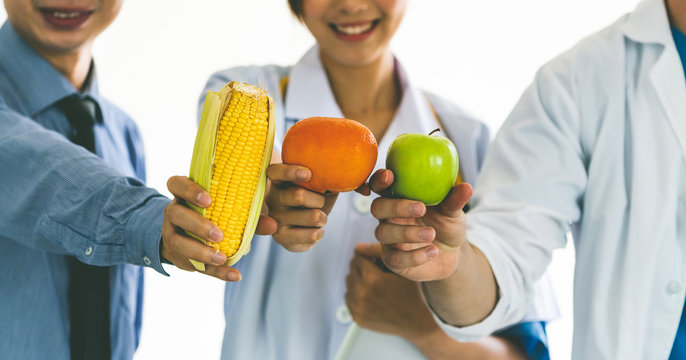 Group of nutritionists presenting diet food of fruit and vegetables for cholesterol control showing awareness and prevention of heart disease. Healthy eating and good nutrition concept. - Powered by Adobe