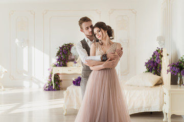 Happy tenderness couple in stylish interior. Well-dressed couple in love hugging in luxury hotel...