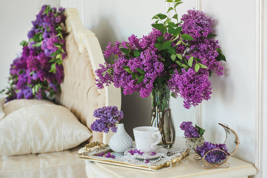 Closeup of lilac floral composition in luxury bedroom interior. Bridal morning decorations