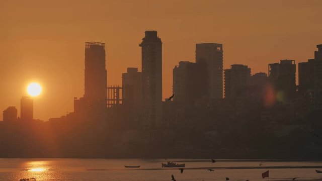 Sunset on the background of Mumbai skyscrapers. View from Chowpatty Beach.
