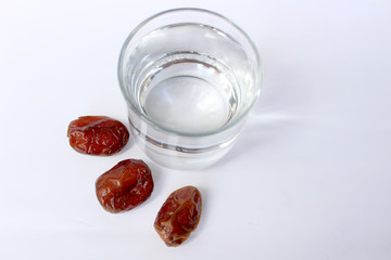 three fruit date or kurma and one glass of water, the concept of food and drink to break the fast of Islam in the month of Ramadan.