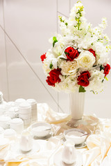 flowers in high glass vases with sugar cups and milk cups for coffee, magnificent,