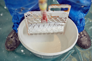 Worker painting walls inside the house - renovation fixes.