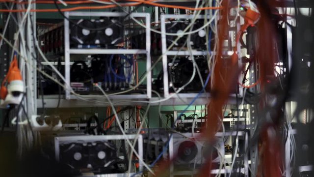 Mining farm for cryptocurrency, electronic devices with wires and cables. Stock footage. Mining bitcoins and cryptocurrency.