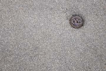 Straße mit kleinem Gullideckel