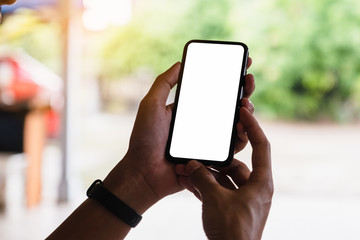Close up Man hand Using a Smart Phone with blank screen at cafe coffee shop.