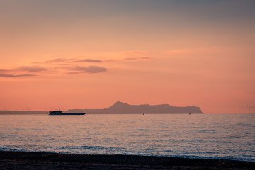 Colourful sunset at the seaside - Vessel leaving bay