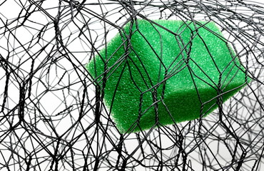 A Green Sponge Trapped inside a Roll of Galvanized Zinc Coated Wire, Showing the Shape and Texture of the Objects.