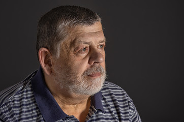 Obraz premium Indoor portrait of bearded Caucasian senior man in low key