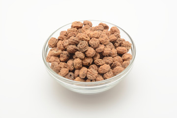 Chufas crudas en un bol de cristal sobre fondo blanco