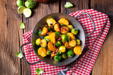 Brussels sprouts potato pan with bacon in rustic style