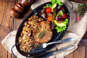 Pork steak with mushrooms and buckwheat groats and mango salad