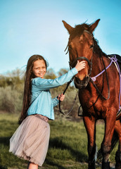 Obraz premium Beautiful girl with horse on the grass. Friendship concept.