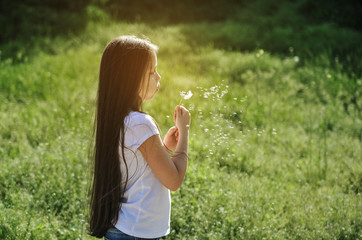 Cute girl with dandelion outdoor. 