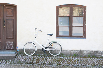 Fototapeta na wymiar Bicycle on the background of the white wall of the house.