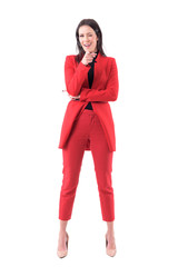 Playful happy business woman pointing finger at you winking at camera. Full body isolated on white background.