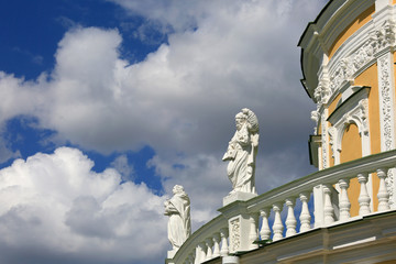 Fragment of the Church of the Nativity of the Blessed Virgin in Podmoklovo, Moscow region, Russia. A rotunda-shaped temple surrounded by statues of the twelve apostles against the sky and clouds