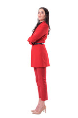 Confident successful female business director in red suit standing with crossed arms. Full body isolated on white background.