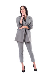 Fototapeta premium Successful business woman in suit looking at camera with hand under chin. Full body isolated on white background.