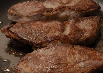 Sizzling Steaks in a Frying Pan