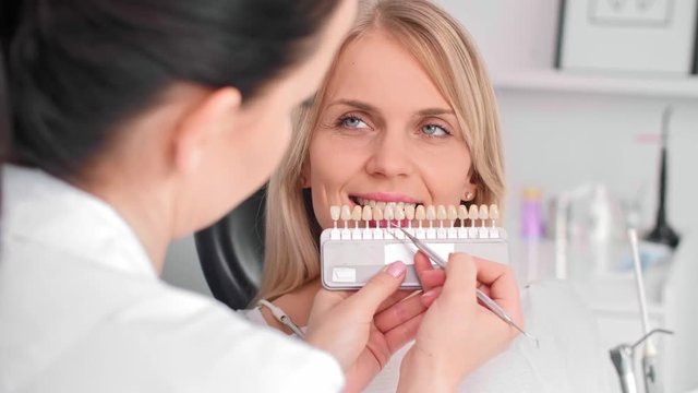 Close up of dentist choosing color teeth from palette