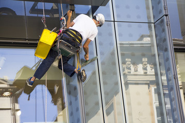 Window washer cleaning the windows of shopping center - 267045312