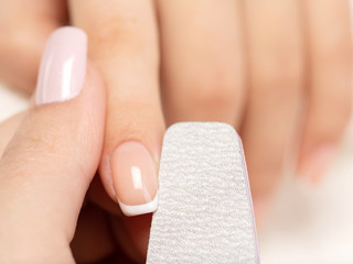 Woman gets manicure procedure in a spa salon. Beautiful female hands.