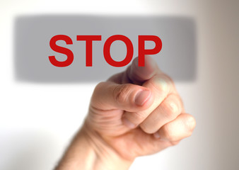 FInger pushing a "STOP" button on a virtual touch screen