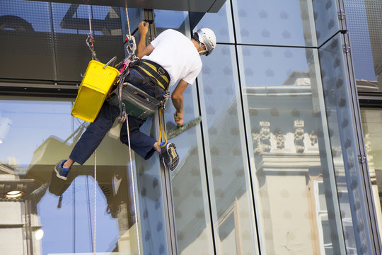 Window washer cleaning the windows of shopping center