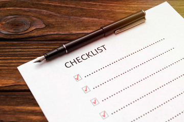 Checklist, fountain pen on wooden background. the concept of business planning. list.