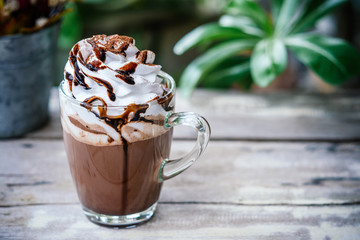 Hot chocolate cocoa in glass mug with whipped cream