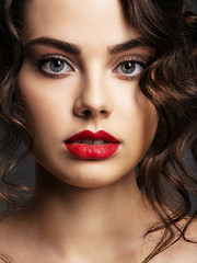 Face of a beautiful woman with a smoky eye makeup and red lipstick