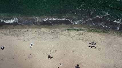 Top view of the sea, ocean. Vacationers on the sand by the water. Photographed from the drone
