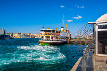 Obraz premium Muslim architecture and water transport in Turkey - Beautiful View touristic landmarks from sea voyage on Bosphorus. Cityscape of Istanbul at sunset - old mosque and turkish steamboats, view on Golden