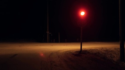 Stop sign red light flashing on dark rural countryside intersectionFlashing red light on top of stop sign in pitch black night on a deserted intersection in the middle of nowhere. Red light is warning - Powered by Adobe