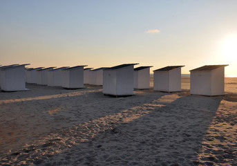 weiße Strandhäuser am Sandstrand in der Abendsonne