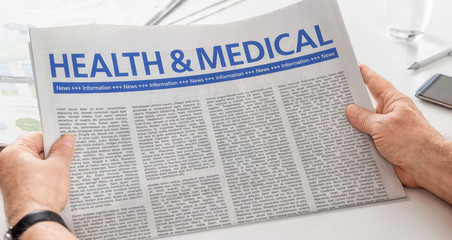 Man reading newspaper with the headline Health and Medical