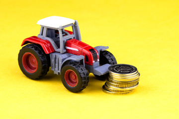 toy tractor crashes into a hill of coins